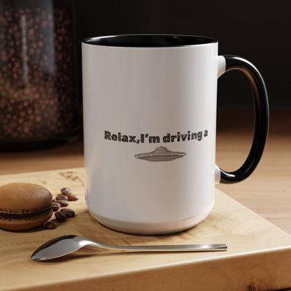 Ceramic coffee mug with "Relax, I’m Driving" and UFO accent design, available in 11 oz or 15 oz sizes.