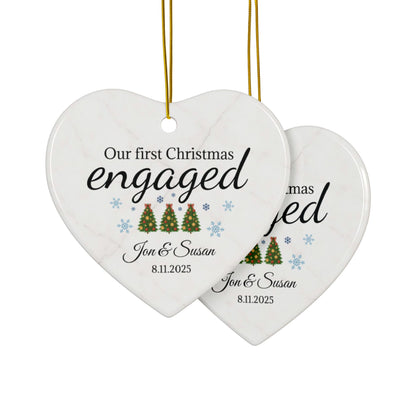 Ceramic "Our First Christmas Engaged" heart ornament with festive red and white design, ideal for celebrating holiday engagement.