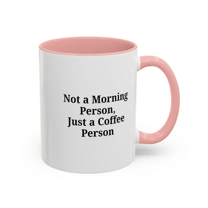 Ceramic coffee mug with "Not a Morning Person, Just a Coffee Person" print, perfect for morning beverages.
