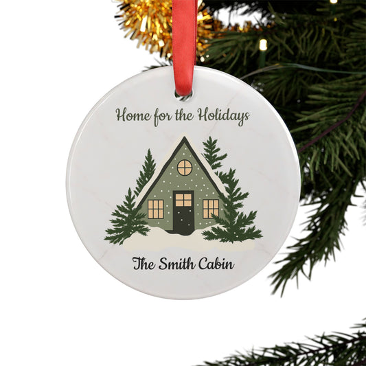 Acrylic "Home for the Holidays" cabin ornament with festive holiday design, ideal for decorating your Christmas tree.