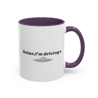 Ceramic coffee mug with UFO accent and "Relax, I’m Driving" text, available in 11 or 15 oz sizes by Printify.