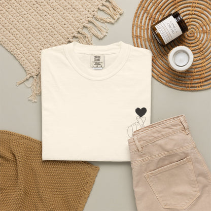 Black T-shirt with minimal heart graphic design, featuring a finger heart illustration on the front, by Printify.