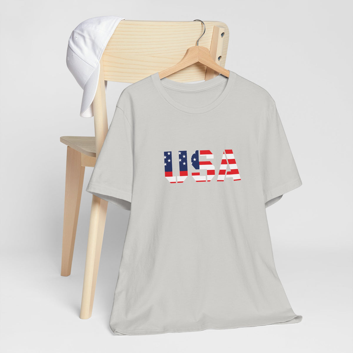 USA flag text T-shirt by Printify featuring patriotic red, white, and blue design perfect for Fourth of July celebrations.