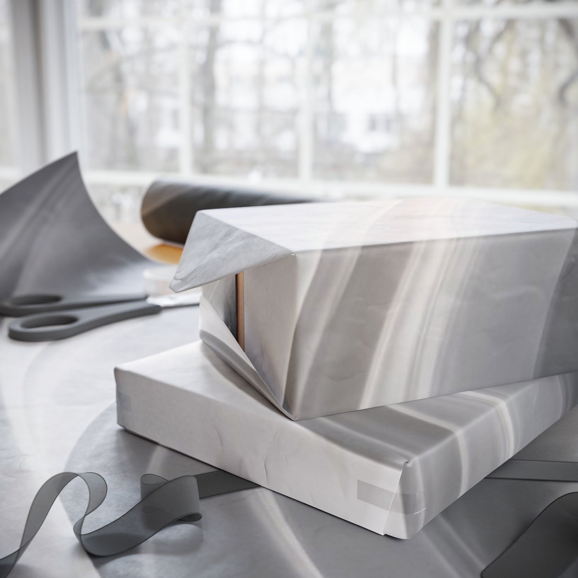 Silver marble swirl wrapping paper with abstract metallic design, ideal for gift wrapping and elegant presentation.