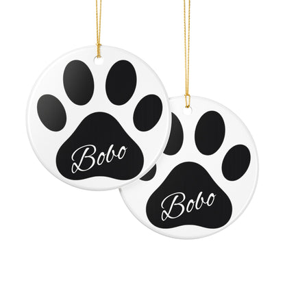 Black paw print ceramic ornament with pet's name, ideal for memorial Christmas decoration, by Printify.