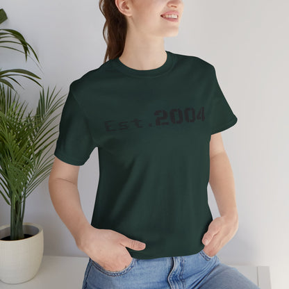 Vintage-style white T-shirt with "Est. 2004" print, minimal design, by Printify, showcasing a casual, retro-inspired look.