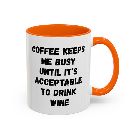 White ceramic mug with black text reading "Coffee Keeps Me Busy Until It's Acceptable to Drink Wine" by Printify, shown on a wooden surface.