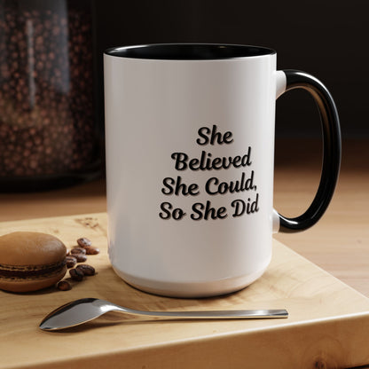 White ceramic motivational coffee mug with black text reading "She Believed She Could, So She Did" on a plain background.