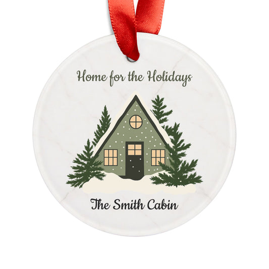 Acrylic "Home for the Holidays" cabin ornament with festive holiday design, perfect for decorating your Christmas tree.