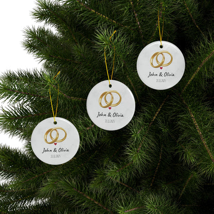 Round ceramic wedding rings ornament with personalized names and date, featuring a decorative design for special occasion decor.