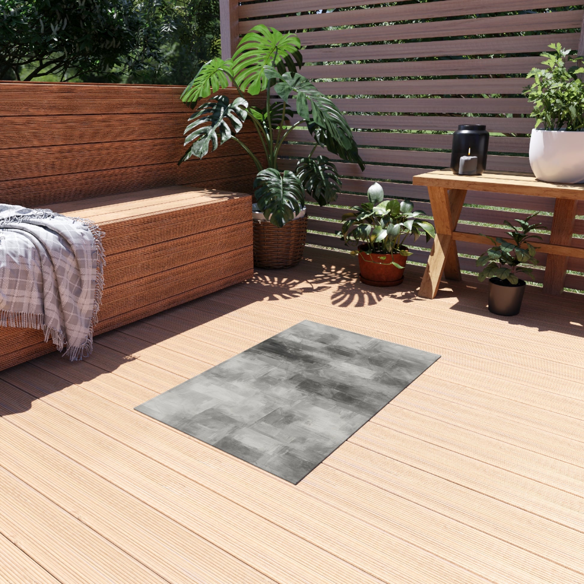 Gray outdoor waterproof rug for patio and deck, shown as a modern blanket-style mat with textured fabric surface.