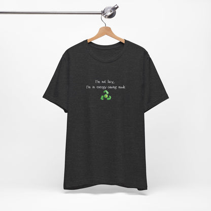 Eco humor T-shirt featuring the phrase "I’m Not Lazy, I’m an Energy-Saving Mock" on a casual Printify T-shirt.