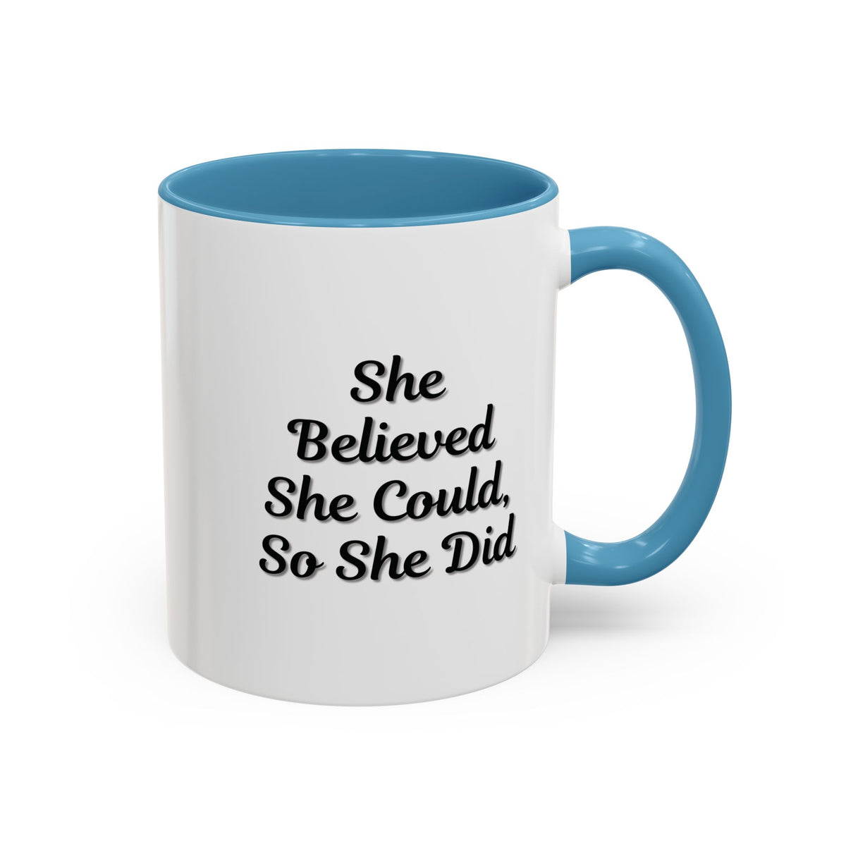 White ceramic motivational coffee mug with black text saying "She Believed She Could, So She Did" on the front.